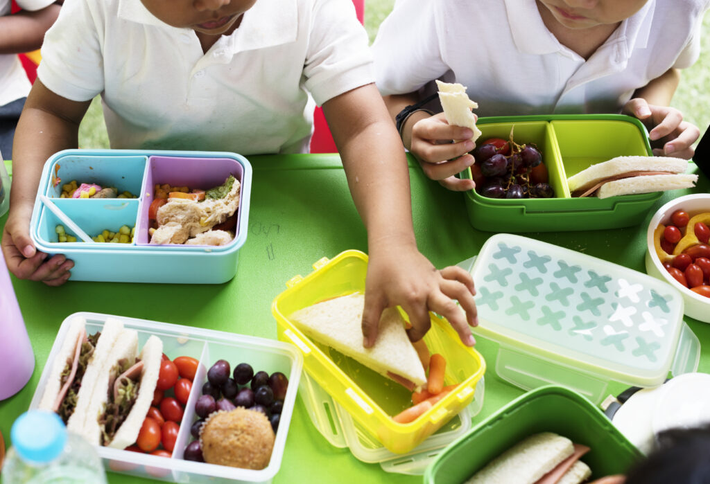 Image of two young children eating lunch in cafeteria