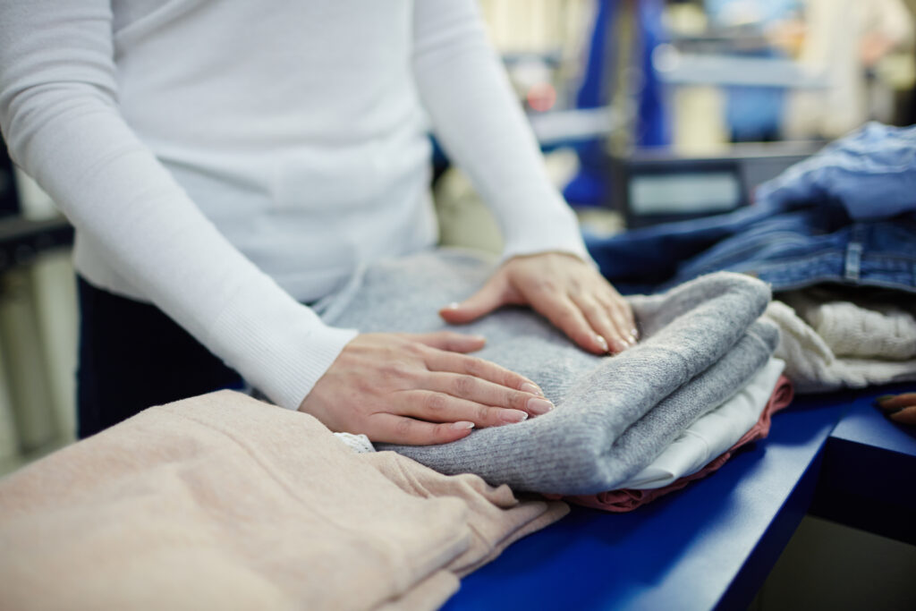 Woman folding clothes at a donation center table